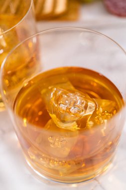 Buzlu viski, viski bardağında, beyaz mermer yüzeyde..