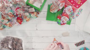 Düz yatıyordu. Adım adım. Ev yapımı macadamia şekerlemesi küçük hediye paketlerine konuyor..