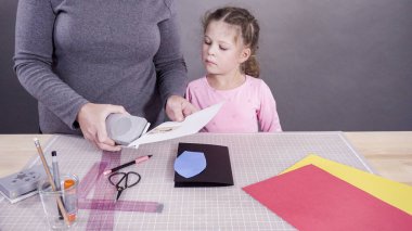 El yapımı Babalar Günü kartı hazırlayan küçük bir kız..