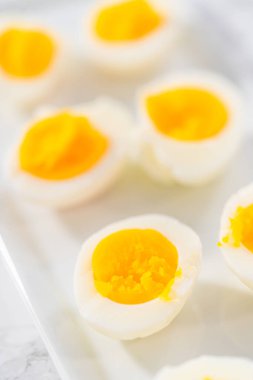 Beyaz servis tabağında dilimlenmiş haşlanmış yumurta..