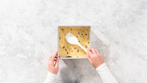 平置きだ 正方形のチーズケーキパンには クランベリー ピスタチオ ファッジを調製するために パルチメント紙が並んでいます — ストック写真