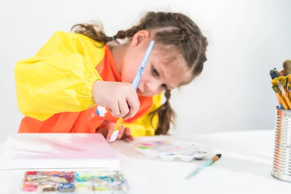 小女孩在家里做一个用丙烯酸作画的艺术项目 — 图库照片
