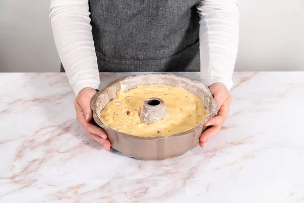 Cake batter in a bundt cake pan to bake apple bundt cake with caramel glaze.