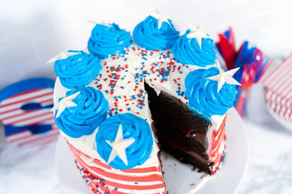 切7月4日巧克力蛋糕 上面装饰有红色 白色和蓝色的奶油糖霜 — 图库照片