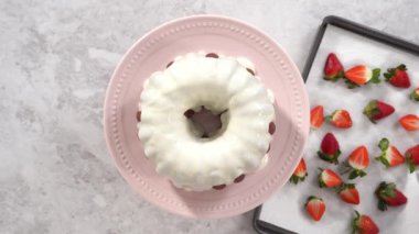 Düz yatıyordu. Adım adım. Yeni pişmiş kırmızı kadife pastayı organik çileklerle süslüyorum..