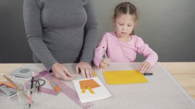 El yapımı Babalar Günü kartı hazırlayan küçük bir kız..