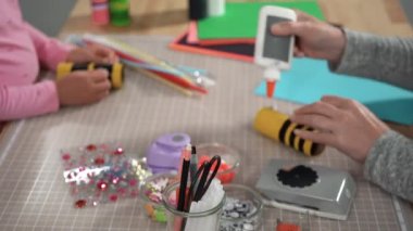 Close up view. Kids papercraft. Making paper bugs out of the empty toilet paper rolls and construction paper.