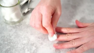 Kadın manikürünü evde basit manikür aletleriyle bitiriyor. Tırnaklarındaki eski ojeleri çıkarıyorum..