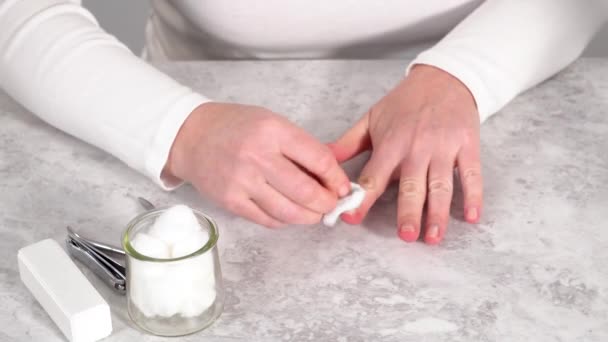 女人在家里用简单的修指甲工具完成她的修指甲 把旧指甲油从指甲油中取出 — 图库视频影像