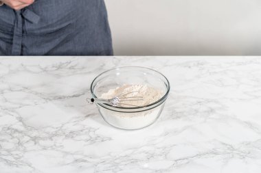 Kuru malzemeleri büyük bir bardakta çırpma kabıyla karıştırıp mini Paskalya ekmeği pişirmek..