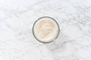 Kuru malzemeleri büyük bir bardakta çırpma kabıyla karıştırıp mini Paskalya ekmeği pişirmek..