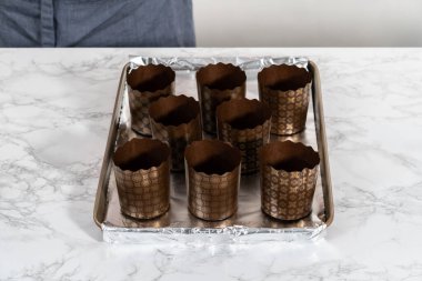 Paskalya ekmeği pişirmek için ekmek hamurunu kağıt kalemin içine karıştırmak..