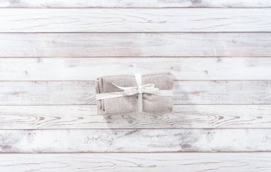 Düz yatıyordu. Beyaz ahşap bir masada yeni bir peçete yığını..