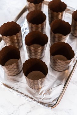 Paskalya ekmeği pişirmek için ekmek hamurunu kağıt kalemin içine karıştırmak..