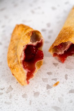 Mutfak tezgahındaki tavada taze pişmiş vişneli börek var..