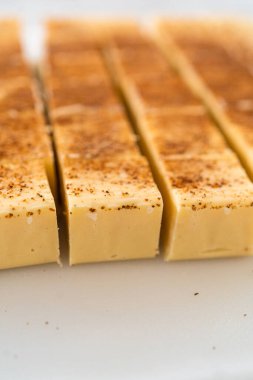 Beyaz bir kesme tahtasındaki ev yapımı yumurta likörü parçaları..