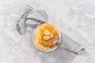 Dilimlenmiş muz ve kızarmış hindistancevizi ile süslenmiş taze hindistan cevizli krep yemek..