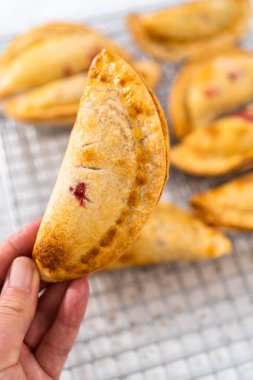 Mutfak tezgahındaki tavada taze pişmiş vişneli börek var..