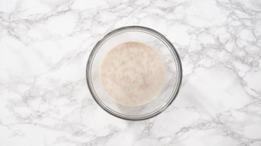 Düz yatıyordu. Adım adım. Ev yapımı çörekler pişirmek için malzemeleri karıştırıyorum..