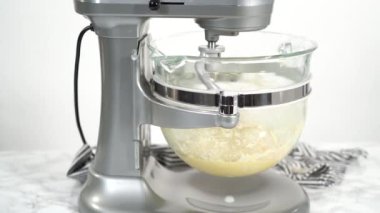 Adım adım. Ev yapımı brioche çörekleri pişirmek için mutfak mikserindeki malzemeleri karıştırıyorum..