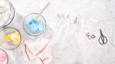 Düz yatıyordu. Adım adım. Tek boynuzlu at meringue kurabiyesi pişirmek için metal uçlu boru torbalarına krema karıştırılıyor..