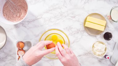 Düz yatıyordu. Adım adım. Kırmızı kadife kek pişirmek için bardakta ıslak malzemeler karıştırıyorum..