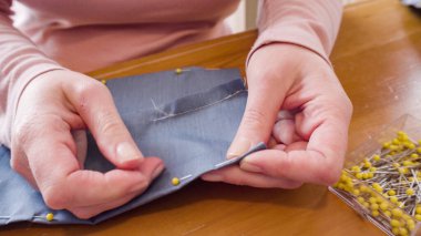 Koronavirüs salgını için dikiş makinesiyle pamuk yüz maskesi dikiyorum..