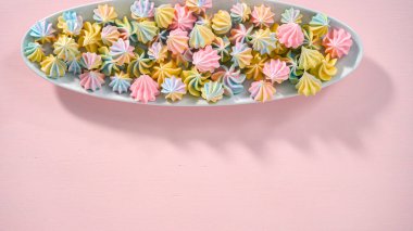 Adım adım. Düz yatıyordu. Beyaz servis tabağında çok renkli tek boynuzlu at kurabiyeleri..