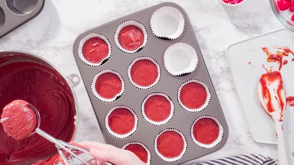 stock image Flat lay. Step by step. Scooping cupcake batter into foil cupcake cups to bake red velvet cupcakes.