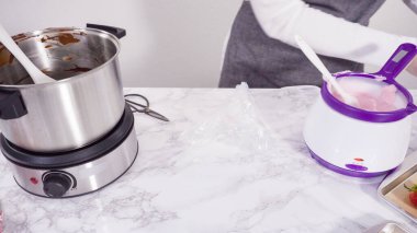 Adım adım. Çikolata parçacıkları eriyen kaplarda eriyor..