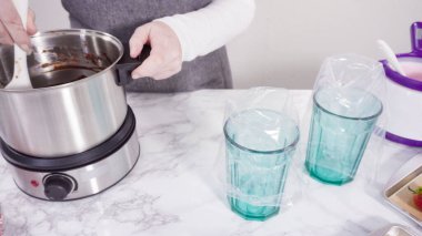 Adım adım. Çikolata parçacıkları eriyen kaplarda eriyor..