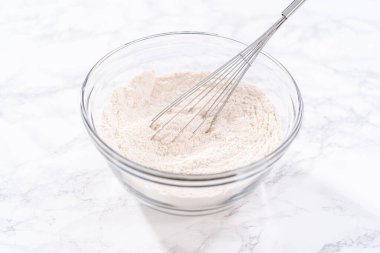 Büyük bir bardakta karıştırılan malzemeler kabaklı kek yapmak için karıştırılıyor..