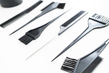 Beyaz arka planda saç rengi ölen plastik fırçalar.