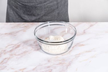 Elmalı Sharlotka keki pişirmek için karışımı büyük bir bardakta karıştırıyorum..