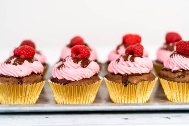 Çikolatalı ahududu kekleri çikolatalı ganache serpiştirilmiş ve üzeri ahududulu..