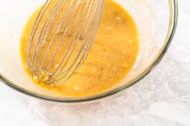 Muzlu kurabiyeleri çikolatalı çiselemeyle karıştırmak için küçük bir bardakta ıslak malzemeler karıştırıyorum..