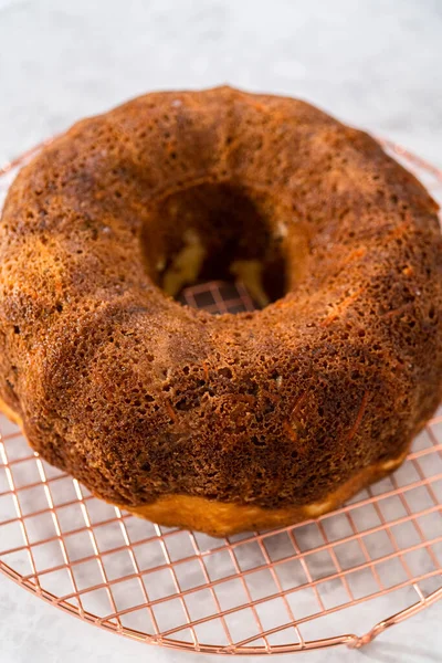 Soğutucu rafı yuvarlamak için taze fırınlanmış havuçlu keki kek kalıbından kaldırıyorum..