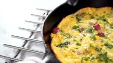 Fırınlanmış ıspanak ve jambonlu frittata dökme demir tavada..