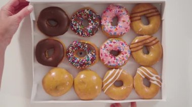 Düz yatıyordu. Beyaz bir karton kutuda mağazadan alınmış donutların çeşitliliği.