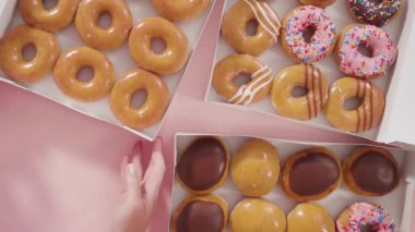 Düz yatıyordu. Beyaz bir karton kutuda mağazadan alınmış donutların çeşitliliği.