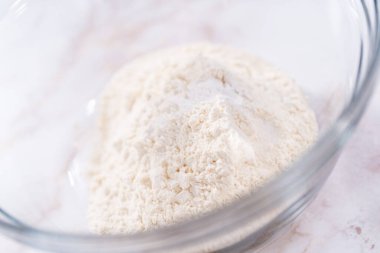 Elmalı Sharlotka keki pişirmek için karışımı büyük bir bardakta karıştırıyorum..