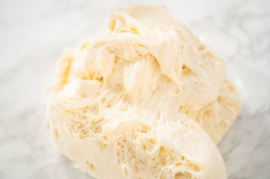 Naneli kremayı hazırlamak için cam bardakta tereyağı çırpma kreması karıştırma kabıyla elektrikli el mikseri..