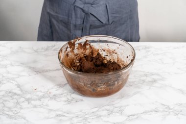 Mixing ingredients with a hand mixer to bake chocolate cookies with chocolate hearts for Valentines Day.
