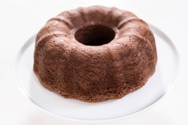 Beyaz pasta standında taze pişmiş çikolatalı kek..