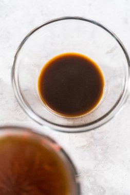 İsveç köftesi sosu pişirmek için cam karıştırma kabında ölçülmüş malzemeler..