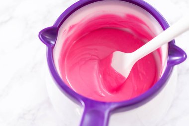 Çikolata kaplı çilek hazırlamak için çikolata parçalarını eritmek..