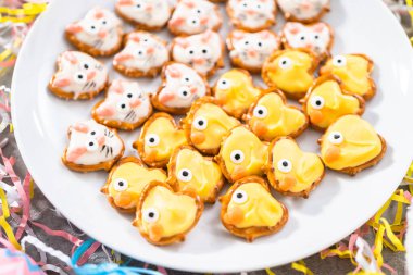 Paskalya çikolatası kaplı simit tavşanlar ve ördek yavruları Paskalya sofrası için beyaz servis tabağında.