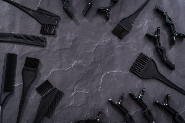 Siyah arka planda saç rengi ölen plastik fırçalar.