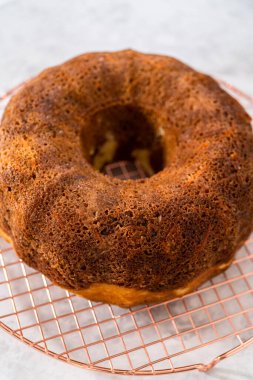 Soğutucu rafı yuvarlamak için taze fırınlanmış havuçlu keki kek kalıbından kaldırıyorum..