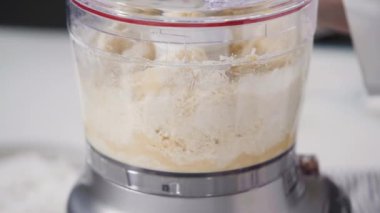 Ev yapımı hindistan cevizi kurabiyeleri hazırlamak için gıda işlemcisinde malzemeler karıştırılıyor..